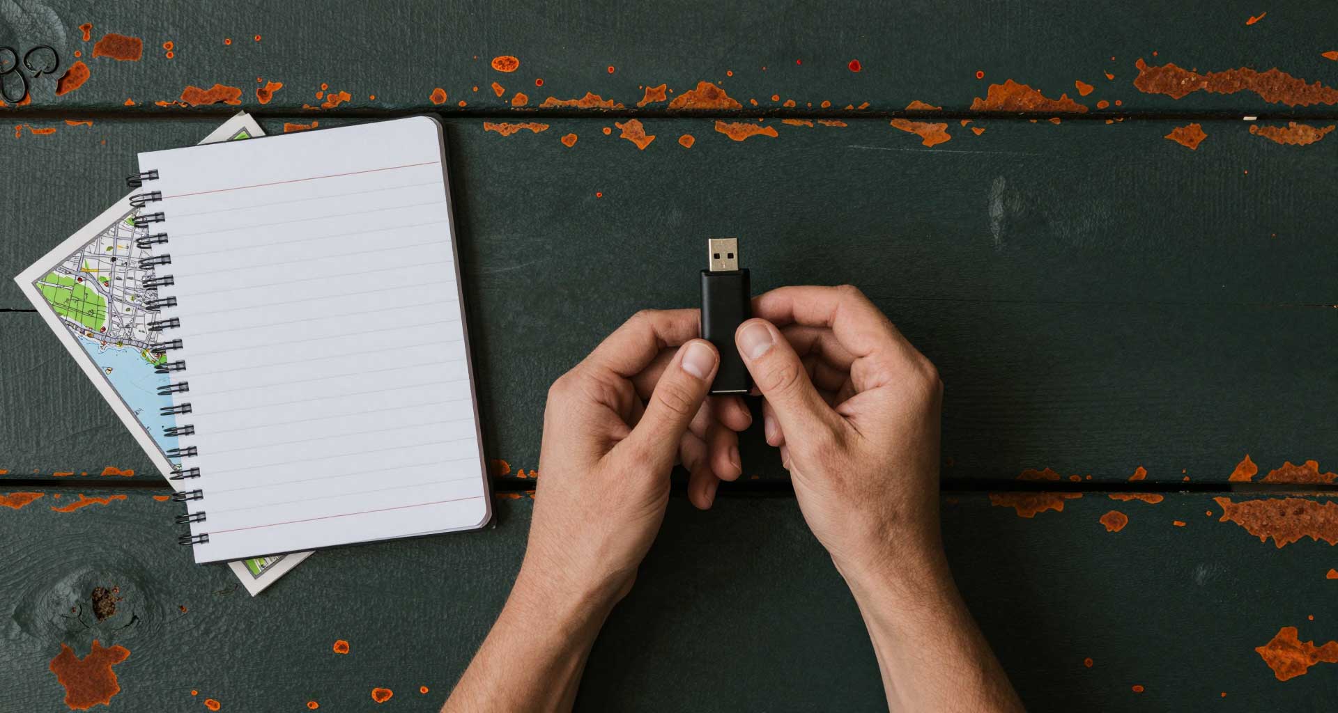 Pendrive z data loggera obok notatnika terenowego i mapy